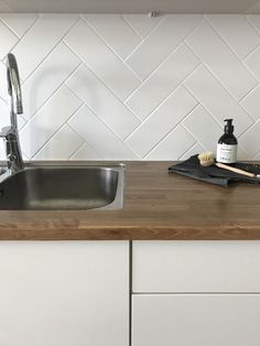 a kitchen counter with a sink, dishwasher and soap