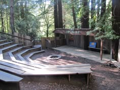 an outdoor seating area in the middle of a forest with stairs leading up to it