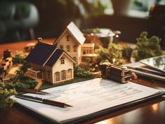 a model house on top of a piece of paper next to a calculator and pen