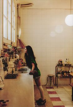 a woman standing in front of a kitchen counter