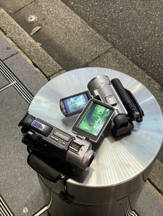 an electronic device sitting on top of a metal table next to a phone charger