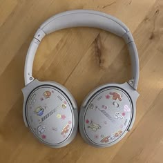 the headphones have cartoon stickers on them, and are sitting on top of a wooden floor