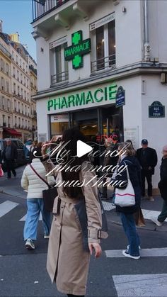 a woman walking across a cross walk in front of a pharmacy