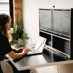 a woman sitting at a desk with a laptop computer in front of her on the screen