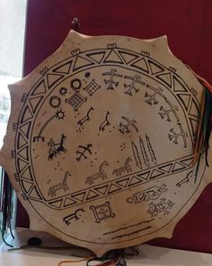 a wooden plate with designs on it sitting on a table