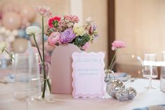 the table is set for a wedding reception with flowers in vases and place cards