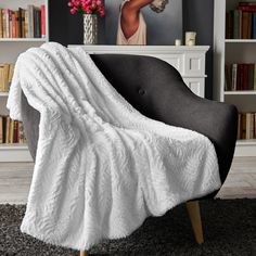 a black chair with a white blanket on it