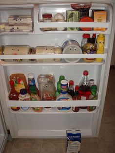 an open refrigerator filled with lots of food and condiments on the bottom shelf