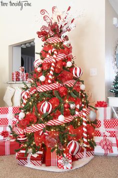 a christmas tree decorated with red and white candy canes, candies and bows