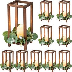 a set of six wooden lanterns filled with flowers and greenery