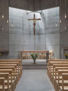 the inside of a church with wooden pews and flowers in front of an altar