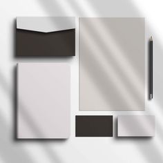 various stationery items are arranged on a white surface, including a notepad, envelope and pencil