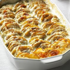 a casserole dish with meat and cheese in it on a white table cloth