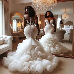 two women standing in front of a mirror wearing dresses made out of paper flowers and pearls