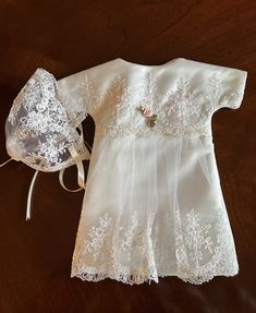 a white dress and bonnet on a wooden table