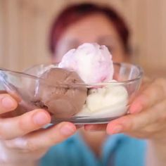 a woman holding a bowl with ice cream and chocolate