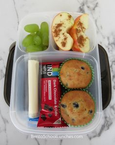 a plastic container filled with fruit and muffins