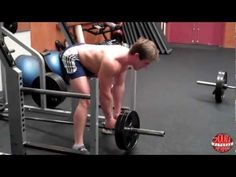 a shirtless man lifting a barbell in a gym