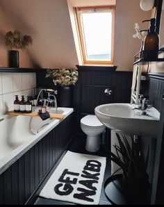 a bath room with a toilet a sink and a bath tub next to a window