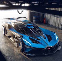 a blue and black sports car parked in a garage