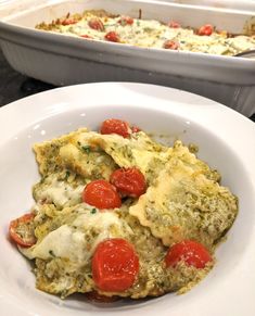 an omelet with tomatoes and cheese in a white bowl next to a casserole dish