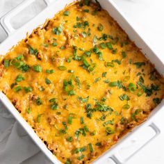 a casserole dish with cheese, meat and green garnish on top