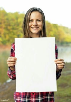 a woman holding up a blank sign in front of her face and smiling at the camera