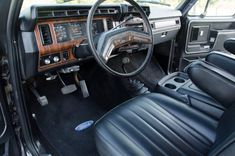 the interior of an older model car with leather seats and steering wheel, including dashboard