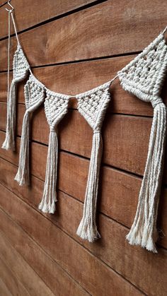 crocheted tassels hanging on the side of a wooden wall