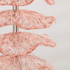 three pink glass vases are stacked on top of each other in the shape of leaves