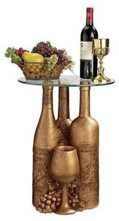 two wine bottles are sitting on a glass table with a bowl of grapes and a bottle of wine next to it