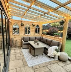 an outdoor living area with patio furniture and string lights