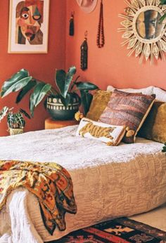 a bedroom with orange walls and lots of plants