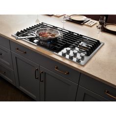 a stove top oven sitting on top of a counter next to a bowl of food