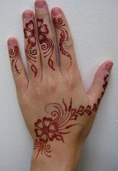 a woman's hand with henna tattoos on it