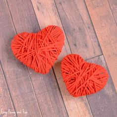 two red heart shaped cushions sitting on top of a wooden floor