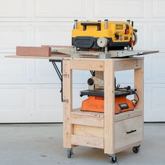 a workbench with a router on top of it in front of a garage door