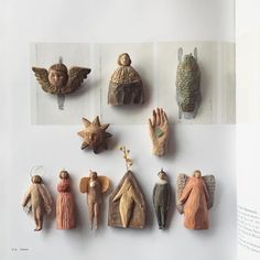 an open book with figurines and pictures of people on the pages, including angels