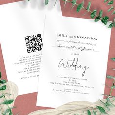 two wedding cards on top of each other with greenery around them and the wording in black ink