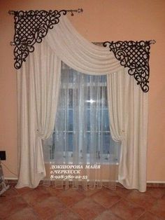 a living room with a large window covered in white curtains and black trimmings