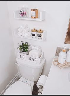 a white toilet sitting in a bathroom next to a sink under a mirror with shelves above it