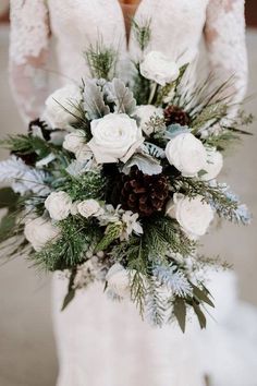 a bridal holding a bouquet of white flowers and greenery