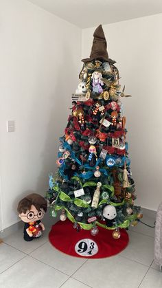 a small christmas tree with harry potter figurines on it and a red rug