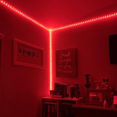 a room with red lights on the ceiling and bookshelves in front of it