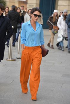 sternyeichen april victoria beckham in orangen hosen blaues hemd braune tasche widder frau Orange Pants Outfit, Pantalon Orange, David And Victoria Beckham, Orange Pants, Orange Fashion