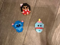 three different types of brooches on a wooden surface, one is blue and the other is red