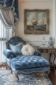 a blue chaise lounge chair sitting in front of a painting