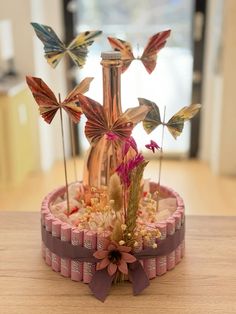 a vase filled with flowers and butterflies on top of a table