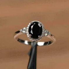 a black and white diamond ring sitting on top of a wooden table