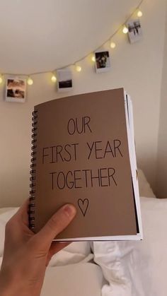 someone is holding up a book with the words our first year together written on it